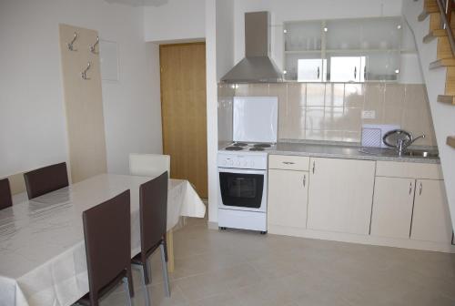 een keuken met een tafel en een witte kookplaat bij Apartments with a parking space Senj - 15376 in Senj