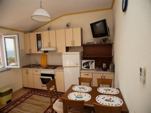 cocina con mesa y 2 sillas y cocina con mesa en Apartments and rooms by the sea Podaca, Makarska - 16114, en Podaca