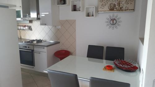 a kitchen with a table and chairs in a kitchen at Apartments by the sea Ploce, Neretva Delta - Usce Neretve - 16195 in Ploče