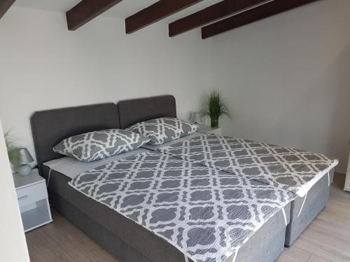 a bedroom with a bed with a black and white comforter at Family friendly house with a swimming pool Kastel Novi, Kastela - 16199 in Kastel Novi