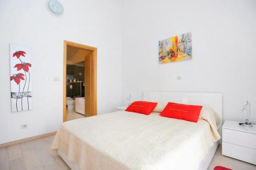 una camera bianca con un letto con due cuscini rossi di Apartments by the sea Trogir - 16211 a Trogir