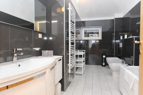 bagno con pareti nere, servizi igienici e lavandino di Apartments by the sea Trogir - 16211 a Trogir