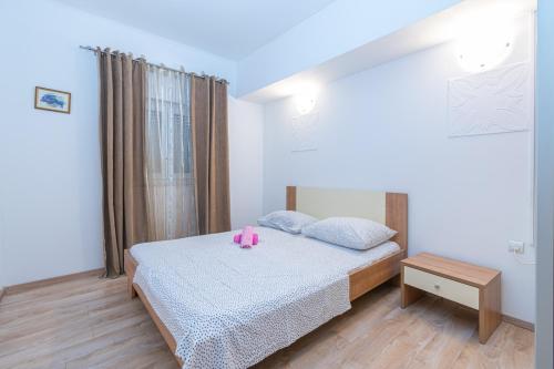 a bedroom with a bed with a pink stuffed animal on it at Apartments with a parking space Bibinje, Zadar - 16188 in Bibinje