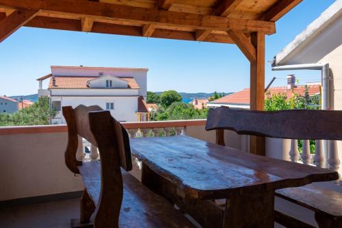 d'une table et de chaises en bois sur un balcon. dans l'établissement Apartments with a parking space Bibinje, Zadar - 16188, à Bibinje