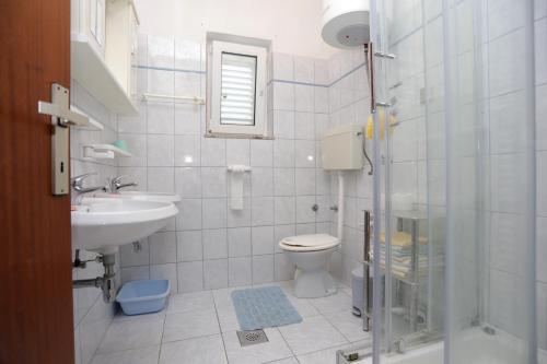 La salle de bains est pourvue de toilettes, d'un lavabo et d'une douche. dans l'établissement Apartments by the sea Rogoznica - 16216, à Rogoznica