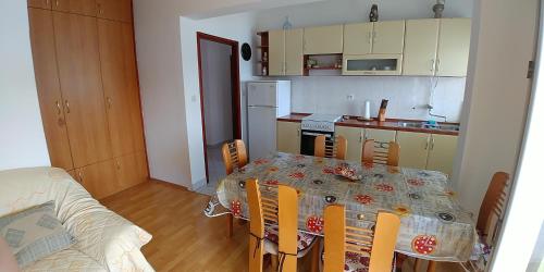 a kitchen with a table and chairs and a kitchen with a table and a table at Apartments by the sea Brgulje, Molat - 16217 in Molat