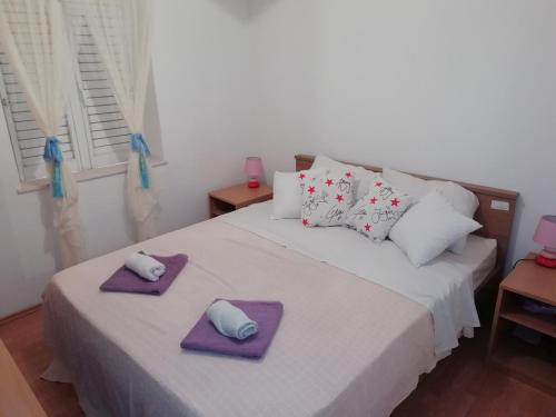 a bedroom with a bed with two towels on it at Apartments with a parking space Luka, Peljesac - 16229 in Ston