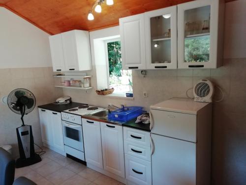 a kitchen with white cabinets and a sink at Apartments with a parking space Luka, Peljesac - 16229 in Ston