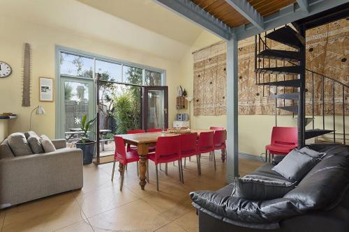 a dining room with a table and red chairs at Large House on Wharf Street in Queenscliff
