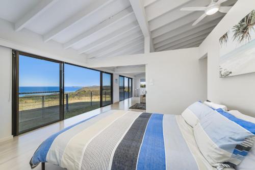 a bedroom with a large bed with a view of the ocean at Ocean Paradise in Bonny Hills