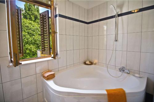 a bath tub in a bathroom with a window at Apartments with a parking space Split - 16247 in Split