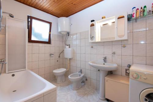 a bathroom with a sink and a toilet and a sink at Apartments by the sea Viganj, Peljesac - 16259 in Kučište