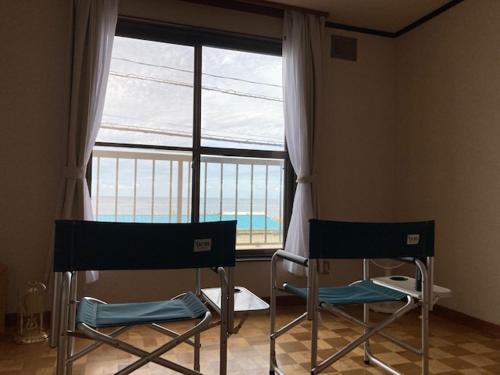- deux chaises dans une chambre avec une grande fenêtre dans l'établissement SPR港家, à Kamuenai