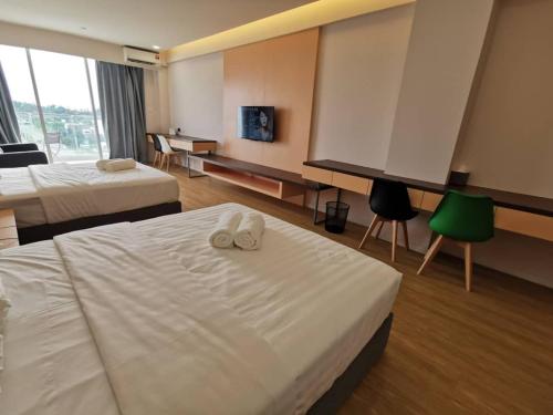 Cette chambre comprend deux lits et une grande fenêtre. dans l'établissement deCore, à Kota Kinabalu