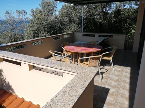 patio con mesa y sillas en el balcón en Apartments by the sea Cove Mulobedanj, Pag - 16285, en Lun