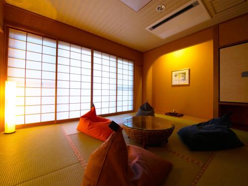 una sala de estar con una habitación con ventanas grandes. en Iki Stellacote Taiankaku, en Iki