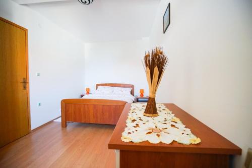 um quarto com uma cama e uma mesa com flores em Apartments by the sea Zdrelac, Pasman - 15318 em Zdrelac