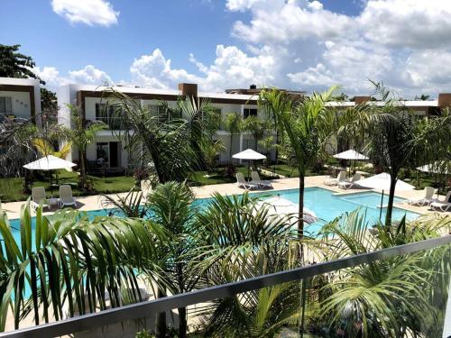 a resort with a swimming pool with chairs and umbrellas at Boca Paraiso, Boca Chica townhouse in Boca Chica