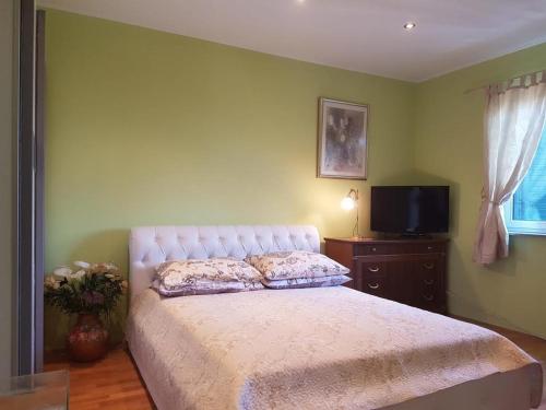 Schlafzimmer mit einem Bett, einem TV und einem Fenster in der Unterkunft Apartments with a parking space Lovran, Opatija - 15973 in Lovran