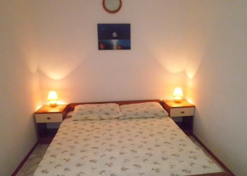 a bedroom with a bed and two lights on two tables at Apartments with a parking space Punat, Krk - 15451 in Punat