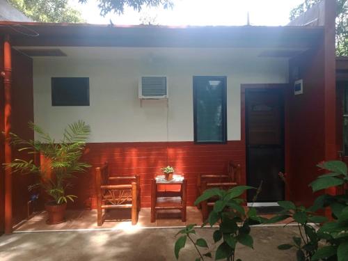 a house with chairs and a table in front of it at Felipa Beach and Guesthouse - Newly Renovated Airconditioned Guest Rooms in Dumaguete