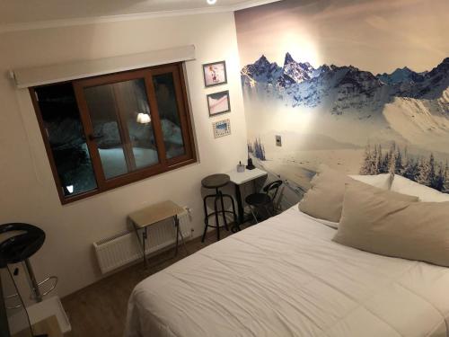 a bedroom with a bed with a mountain mural on the wall at Departamento residencial Valle Nevado in Lo Barnechea