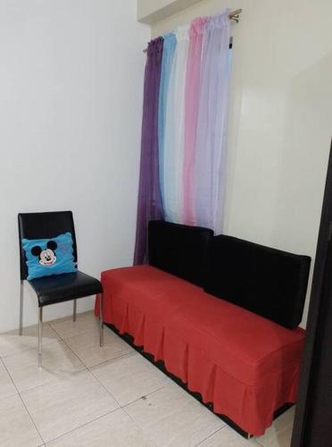 a red couch and a chair in a room at Affordable Condo for Rent in Valley Mansions in Cainta