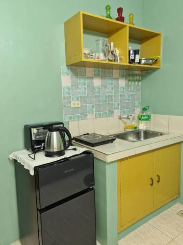 Il comprend une petite cuisine équipée d'un évier et d'un lave-vaisselle. dans l'établissement Affordable staycation in Valleygolf, à Cainta