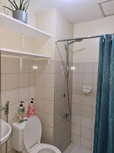 La salle de bains est pourvue d'une douche, de toilettes et d'un lavabo. dans l'établissement Affordable staycation in Valleygolf, à Cainta