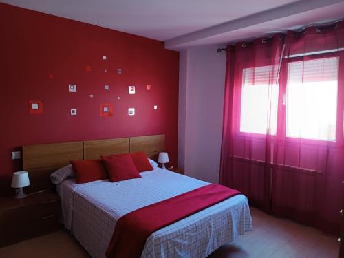 una camera da letto con pareti rosse e un letto con cuscini rossi di Manzanares a Manzanares