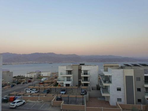 a view of a parking lot with buildings and a body of water at Dream house in Eilat