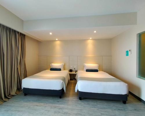 two beds in a hotel room with two beds at Solea Mactan Resort in Mactan
