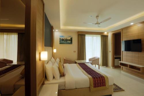 Habitación de hotel con cama y TV de pantalla plana. en Hotel Sakura by Maps en Gurgaon
