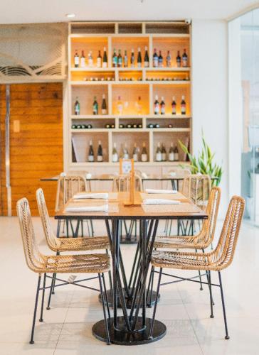 a dining room table with chairs and a shelf of vases at Solea Mactan Resort in Mactan
