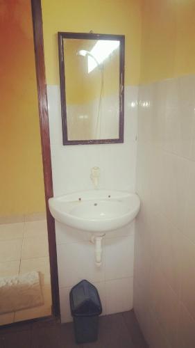 La salle de bains est pourvue d'un lavabo et d'un miroir. dans l'établissement Family bungalow, à Gili Meno