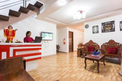 a woman standing at a counter in a living room with a laptop at Vostro e Nostra in Vigan