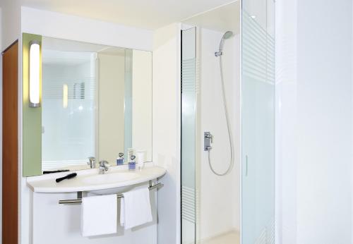 a bathroom with a sink and a shower at ibis budget Basel City in Basel
