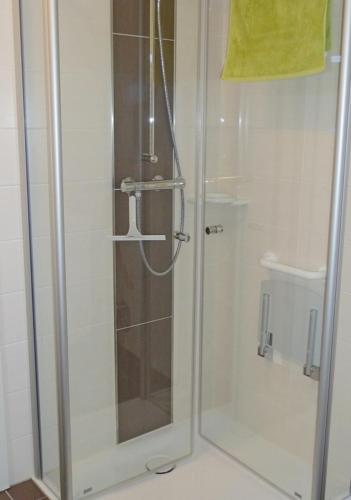 a shower with a glass door in a bathroom at Heubude in Greetsiel