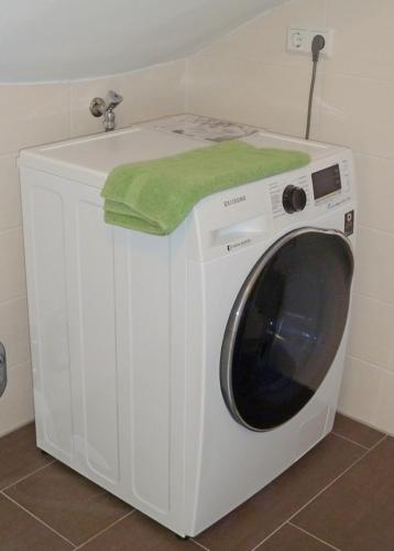 a washing machine with a green towel on top of it at Heubude in Greetsiel