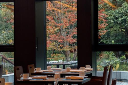 a dining room with tables and chairs and trees at Four Seasons Hotel Kyoto in Kyoto
