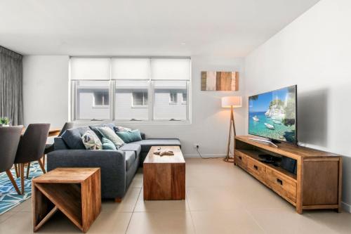 a living room with a couch and a tv at Aquaview Unit 304 Kings Beach in Caloundra