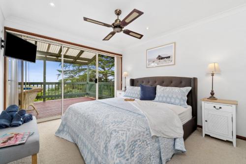 a bedroom with a bed with a ceiling fan at Bells Rest with a view in Kurrajong