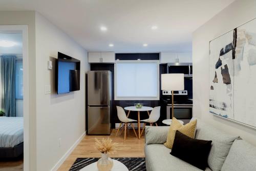 a kitchen and living room with a couch and a table at Modern, Luxurious Apartment near Downtown Ottawa in Ottawa