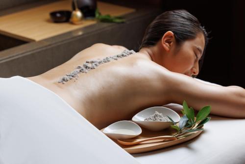 a woman laying in a bathtub with a plate of food at Four Seasons Hotel Kyoto in Kyoto