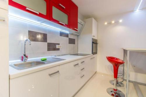 a kitchen with a sink and a red cabinet at Apartments with a parking space Jusici, Opatija - 15874 in Kastav