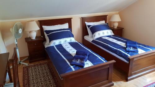 two beds in a bedroom with blue and white sheets at Rooms by the sea Rava, Dugi otok - 15880 in Rava