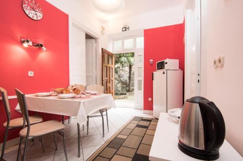 jadalnia z czerwonymi ścianami oraz stołem i krzesłami w obiekcie Apartments with WiFi Rijeka - 15844 w mieście Rijeka
