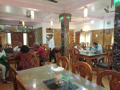um grupo de pessoas sentadas às mesas de um restaurante em Dichang Resorts em Guwahati