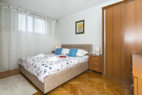 a bedroom with a bed and a dresser and a window at Apartments with WiFi Split - 15862 in Split