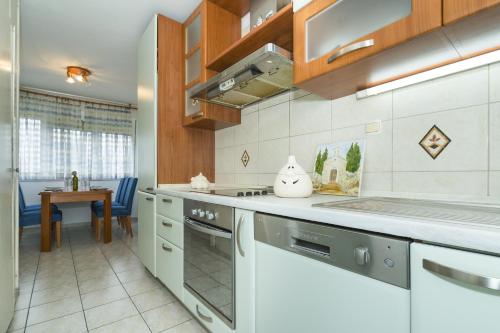 a kitchen with a stove top oven next to a table at Apartments with WiFi Split - 15862 in Split